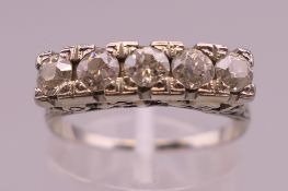 An unmarked white gold five stone diamond ring. Ring size O/P.