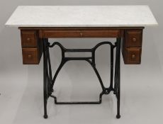 A Victorian sewing machine table fitted with a marble top. 102 cm wide.