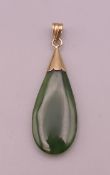 A gold mounted jade pendant. 4 cm high excluding suspension loop.