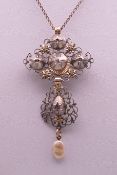 An unmarked white and yellow metal rough cut diamond and pearl set pendant/brooch on chain.