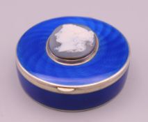 A silver and enamel box with cameo mount to the lid. 6 cm diameter.