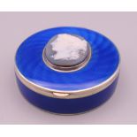 A silver and enamel box with cameo mount to the lid. 6 cm diameter.