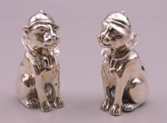 A pair of sterling silver dog form salt and peppers. 6 cm high.