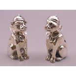 A pair of sterling silver dog form salt and peppers. 6 cm high.