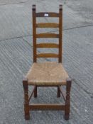 An Arts and Crafts ladder back chair.