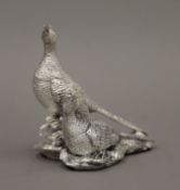 A filled silver model of a pair of pheasants. 11 cm high.