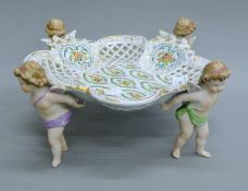 A Continental ceramic tazza decorated with four cherubs. 32 cm diameter.