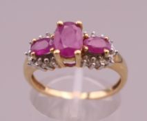 A 14 K gold three stone ruby ring. Ring size P. 3.2 grammes total weight.