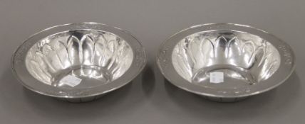 A pair of silver dishes, with embossed fruit decoration. Each approximately 16 cm diameter. 11.