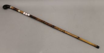 A late 19th/early 20th century silver collared bamboo sword stick. 95 cm long.
