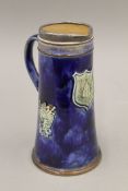 A Royal Doulton silver rimmed stoneware jug with B.S.A Shooting Cup insignia. 21 cm high.