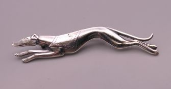 A silver greyhound form brooch. 7 cm long.