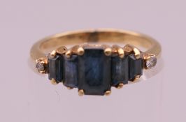 An 18 K gold seven stone sapphire and diamond ring. Ring size J. 2.3 grammes total weight.