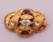 A Victorian unmarked 18 ct gold, aquamarine and garnet brooch, boxed. 3.5 cm long. 3.