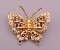 An 18 ct gold, diamond and sapphire butterfly form brooch. 2.5 cm wide. 4.7 grammes total weight.