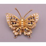 An 18 ct gold, diamond and sapphire butterfly form brooch. 2.5 cm wide. 4.7 grammes total weight.