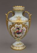 A gilt heightened Coalport porcelain twin handled vase decorated with fruit and flowers,