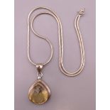 A silver and citrine pendant on a silver chain. Pendant 2.