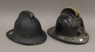 Two vintage firemen helmets.