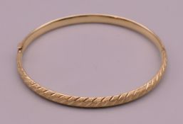 A 10 K gold bangle form bracelet. 6 cm internal diameter. 3.9 grammes.