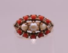 A 9 ct gold coral and seed pearl ring. Ring size N/O. 2.9 grammes total weight.