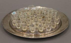 A silver plated tray set with shot glasses. 31 cm diameter.