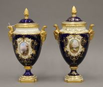 A pair of gilt heightened Coalport porcelain twin handled lidded vases painted with scenic