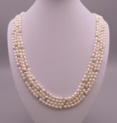 A four strand pearl necklace with 14 ct gold clasp. 60 cm long.