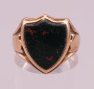 A 9 ct gold bloodstone shield signet ring. Ring size O. 5.1 grammes total weight.