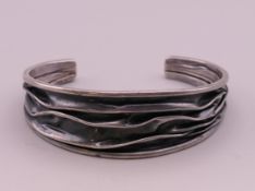A modernist silver bangle. 6.5 cm wide.