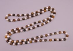 A tiger's eye and pearl necklace. Approximately 120 cm long.