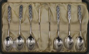 A boxed set of six Liberty and Co enamelled decorated silver teaspoons and matching tongs.