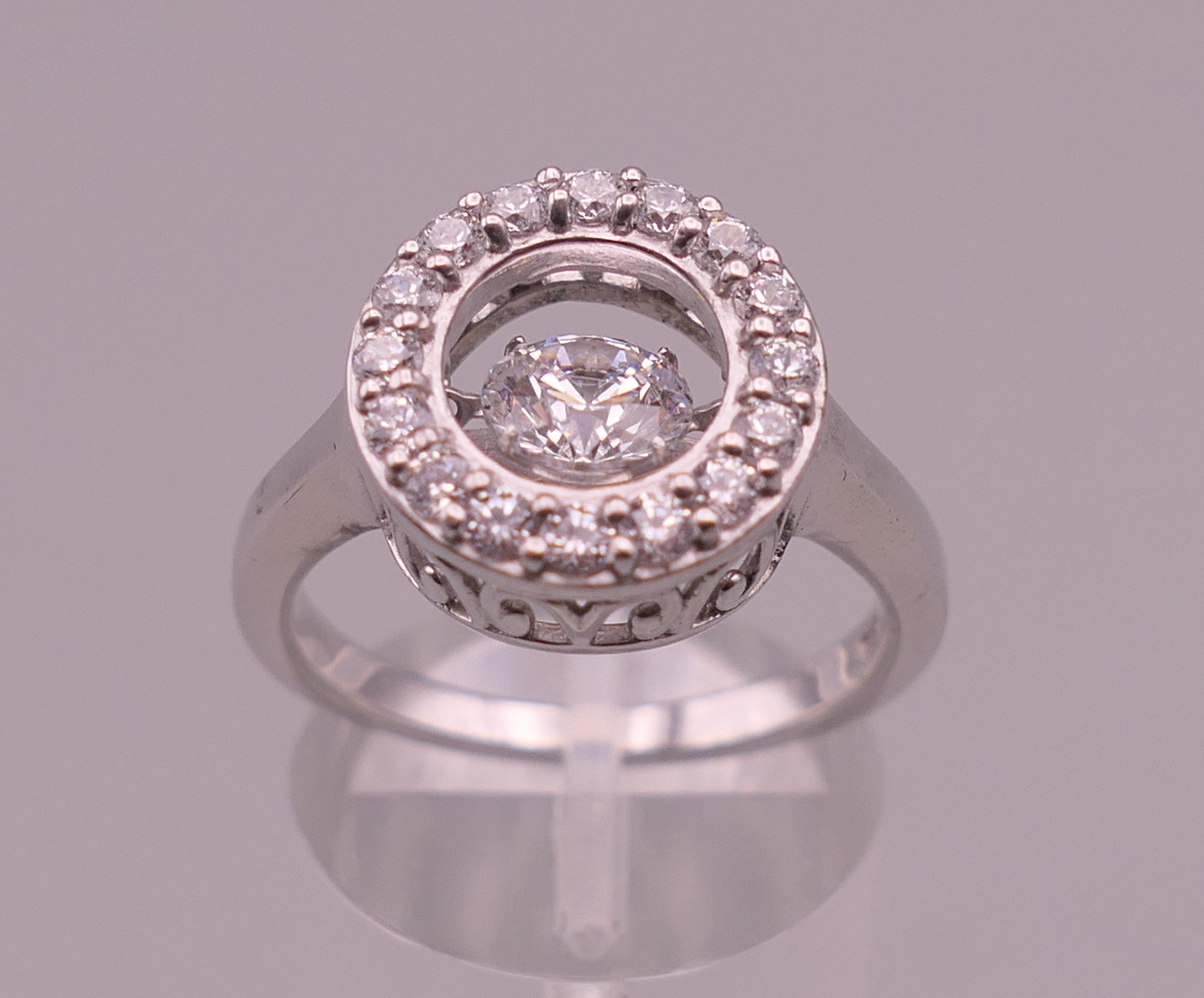 A silver 'swinging' central stone cubic zirconia ring. Ring size Q.