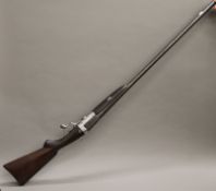 An 8 bore hammer gun, maker unknown, with Jones rotary under lever, with blacked Damascus barrels,