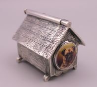 A silver vesta formed as a dog's kennel. 4 cm high.
