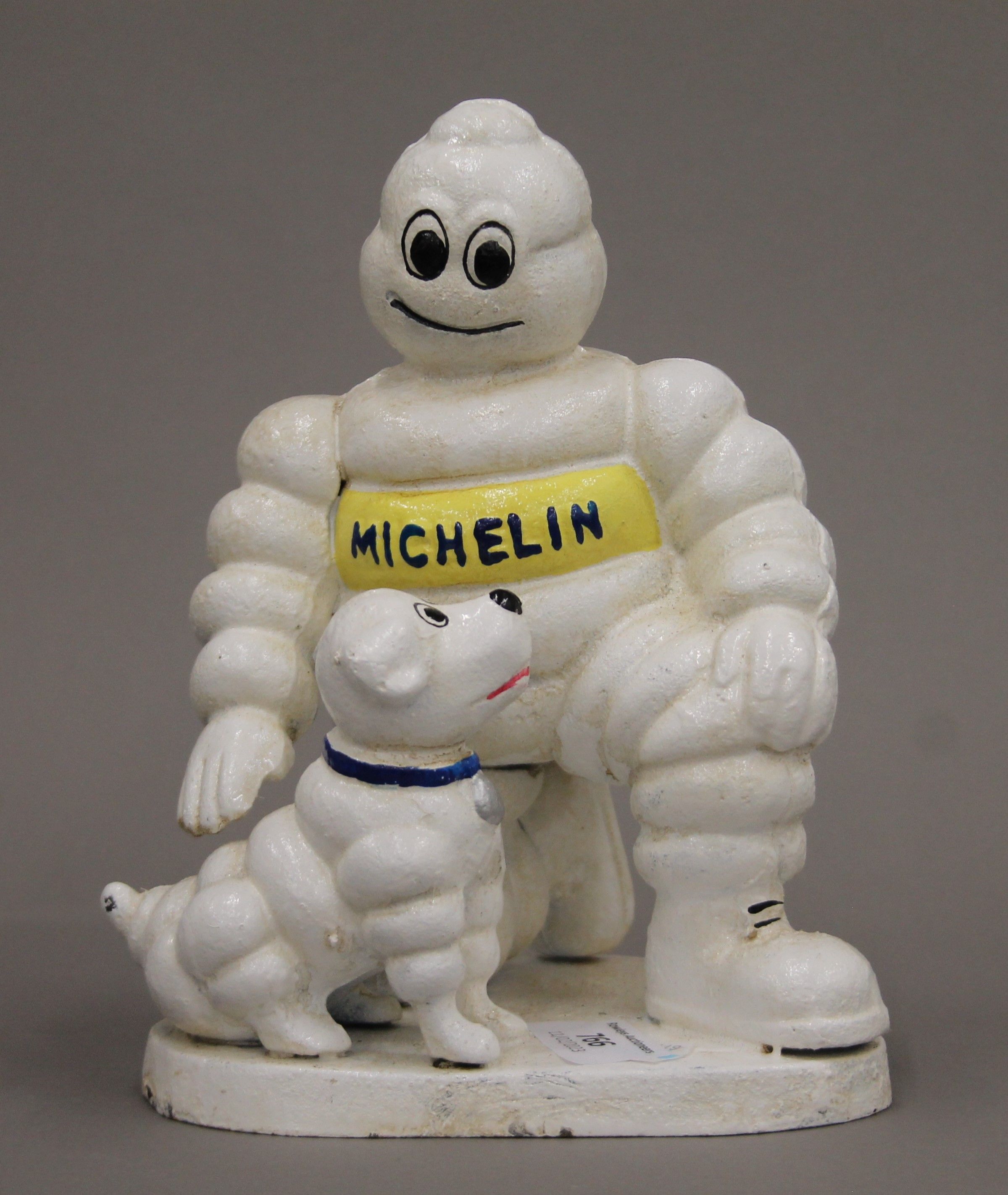 A cast iron Michelin Man and dog. 20 cm high.