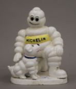 A cast iron Michelin Man and dog. 20 cm high.