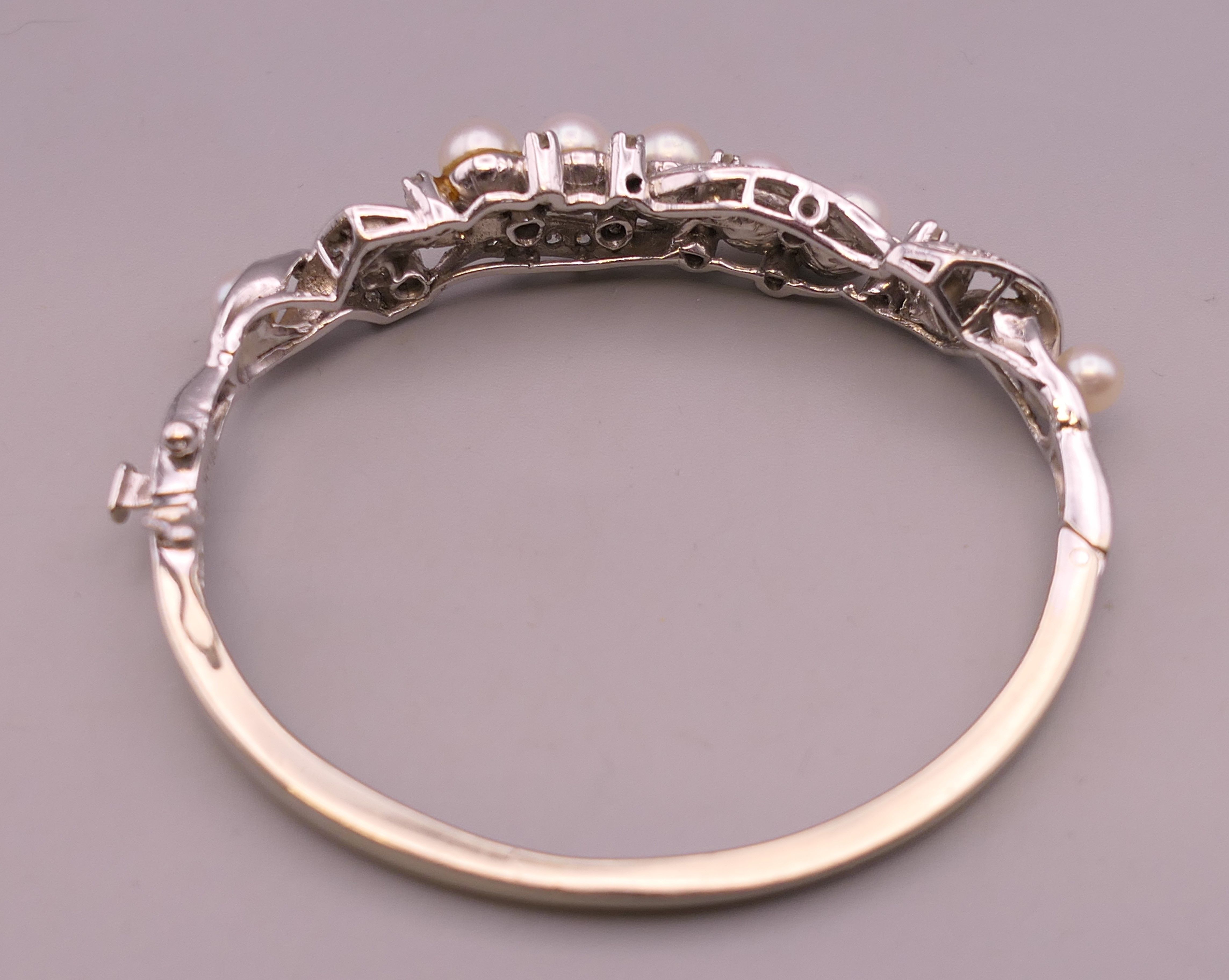 A 14 K white gold diamond and pearl bangle. 5 cm internal diameter. 16.5 grammes total weight. - Image 5 of 7