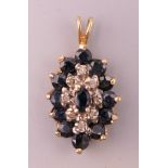 A 14 K gold diamond and sapphire pendant. 2 cm high excluding suspension loop.