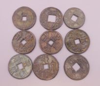 Nine Chinese coins. Approximately 3 cm diameter.