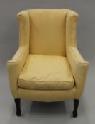 An Edwardian yellow upholstered armchair. 75 cm wide.