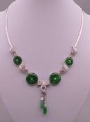 An 18 ct white gold jade and diamond necklace. Approximately 42 cm long. 40.9 grammes total weight.