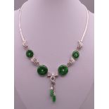 An 18 ct white gold jade and diamond necklace. Approximately 42 cm long. 40.9 grammes total weight.