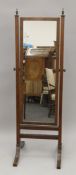 A mahogany cheval mirror. 143 cm high.