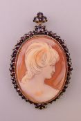 A silver gilt and garnet cameo brooch. 5.5 cm high including suspension loop.