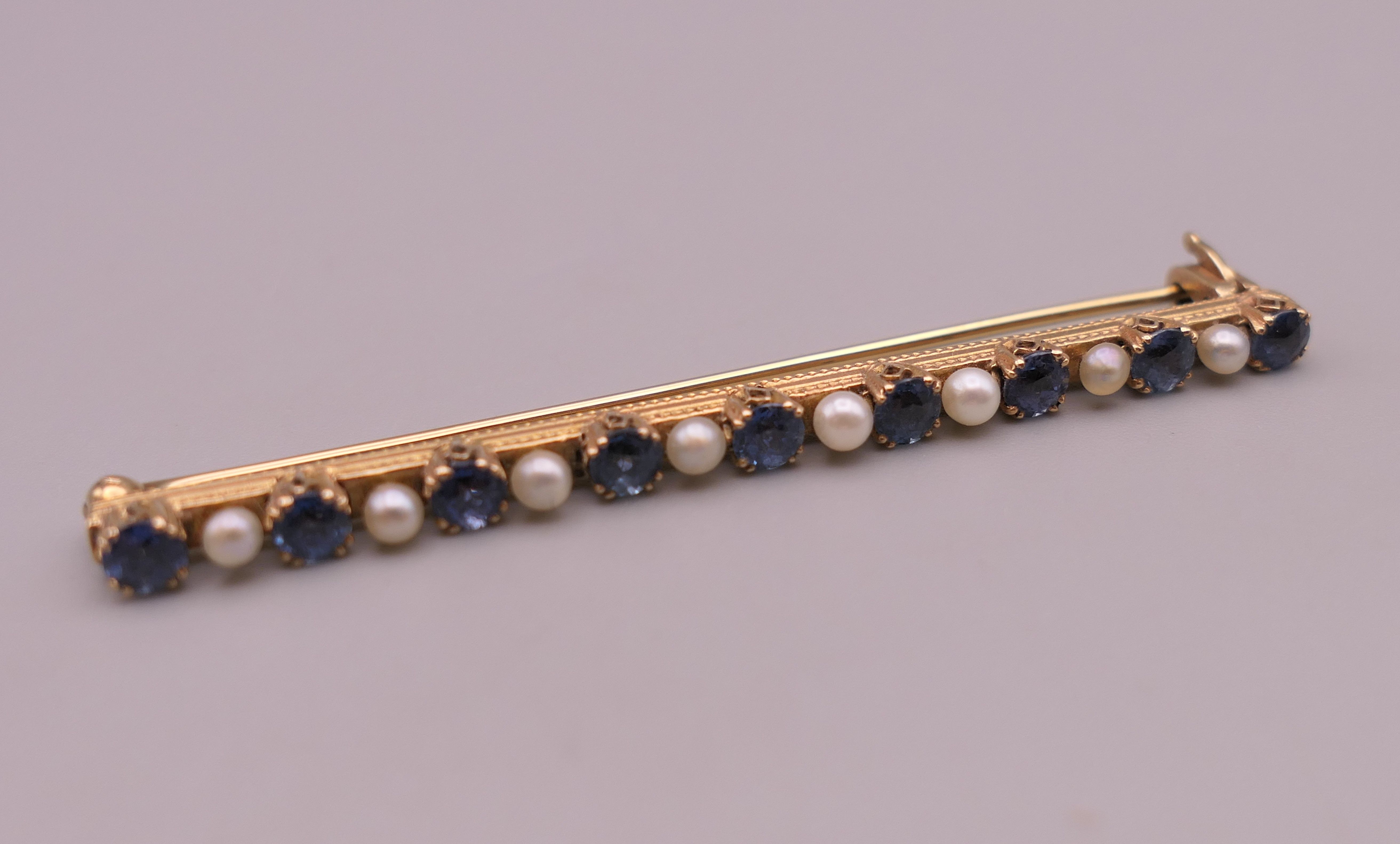 An antique natural sapphire and seed pearl unmarked gold (high carat tested) brooch, boxed. - Image 2 of 10