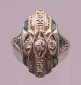 An 18 K white gold Art Deco style emerald and diamond ring. Ring size K/L. 4.