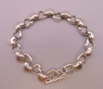 A silver heart and cupids arrow form bracelet. 20 cm long.
