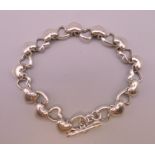 A silver heart and cupids arrow form bracelet. 20 cm long.