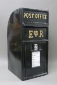 A black post box. 65 cm high.